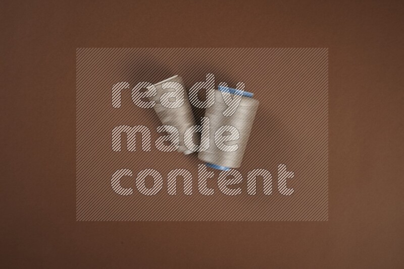 A brown collection of sewing and tailoring tools arranged on a brown background