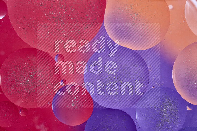 Close-ups of abstract oil bubbles on water surface in shades of red, orange and purple