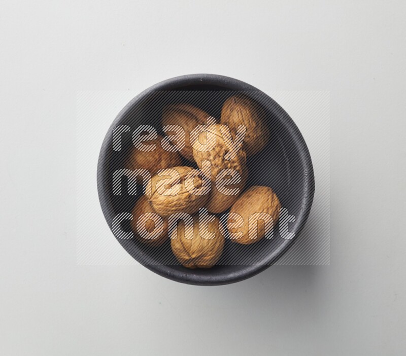 Top-view shot of walnut in a container on white background
