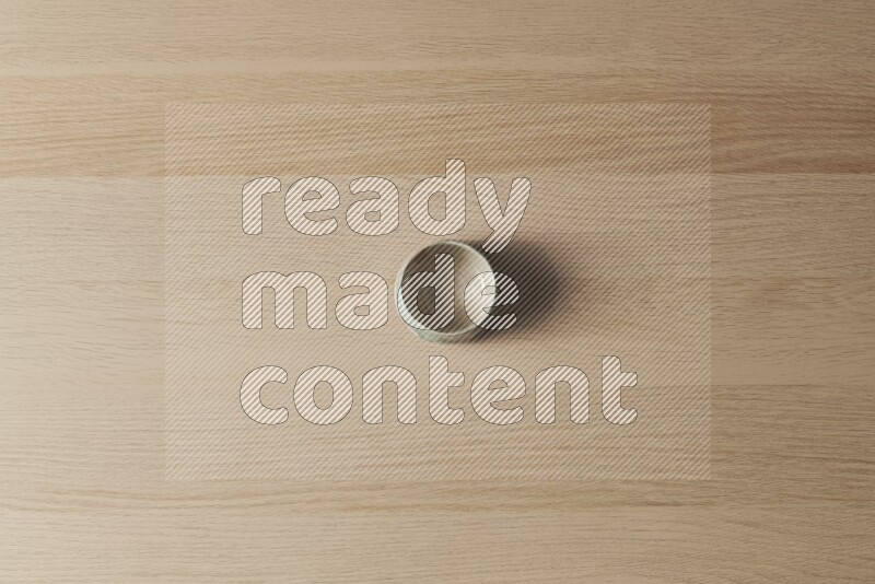 A multicolored pottery bowl on light wooden background