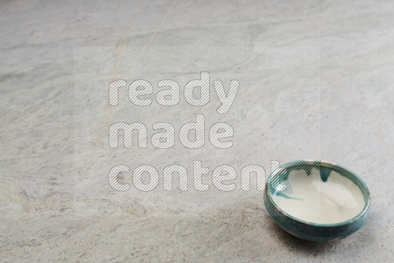 A multicolored pottery bowl on grey marble background