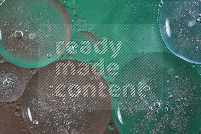 Close-ups of abstract oil bubbles on water surface in shades of green and brown