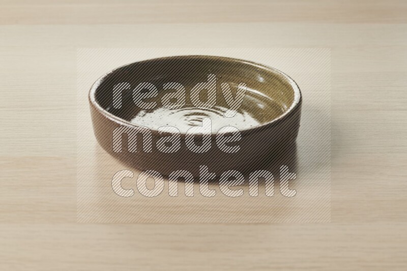 وعاء فرن فخاري متعدد الألوان علي خلفية خشبية فاتحة