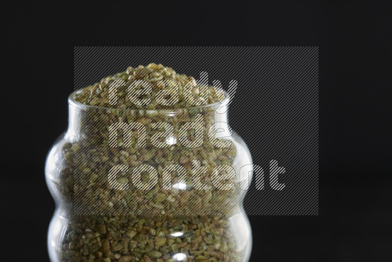 Freekeh in a glass jar on black background
