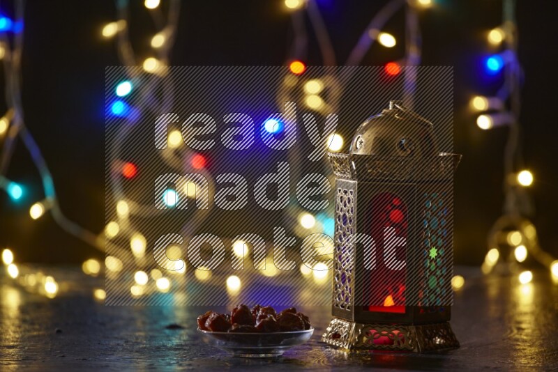 A traditional ramadan lantern surrounded by glowing fairy lights in a dark setup