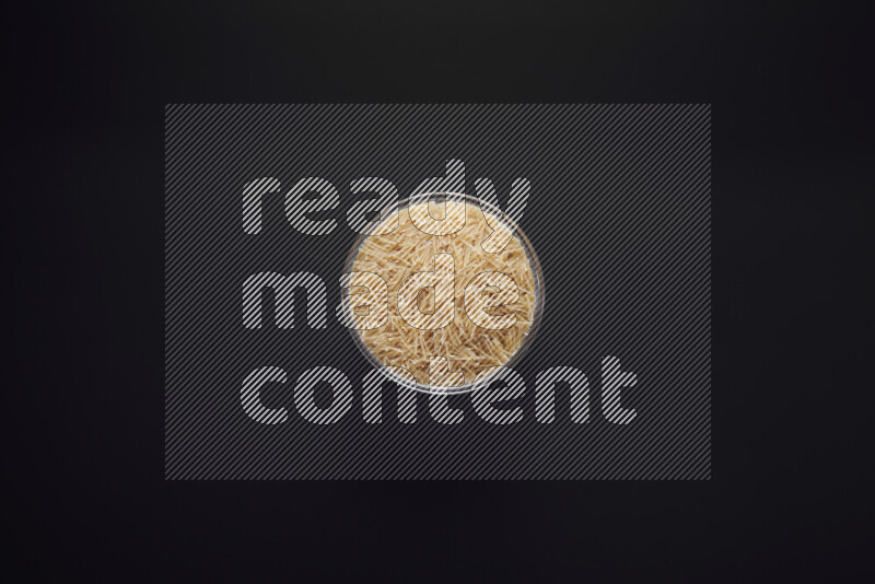 Vermicelli pasta in a glass bowl on black background