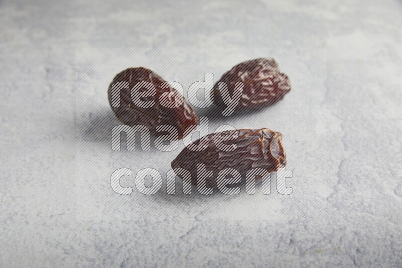 three madjoul dates on a light grey background