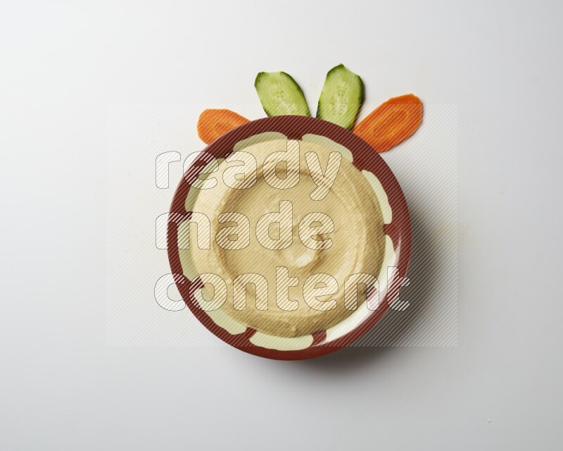 Plain hummus in a traditional plate on a white background