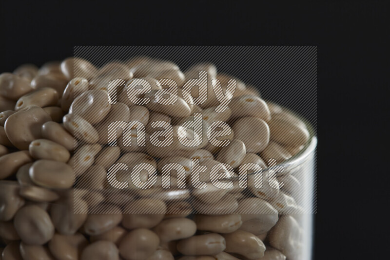 Lupin Beans in a glass jar on black background