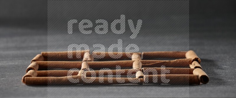 9 empty squares of cinnamon sticks on black flooring