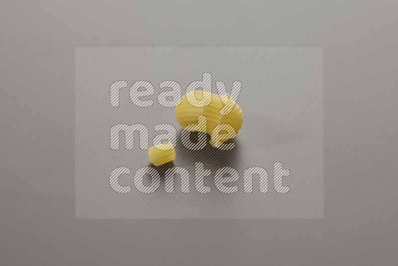 Small rings pasta with other types of pasta on grey background
