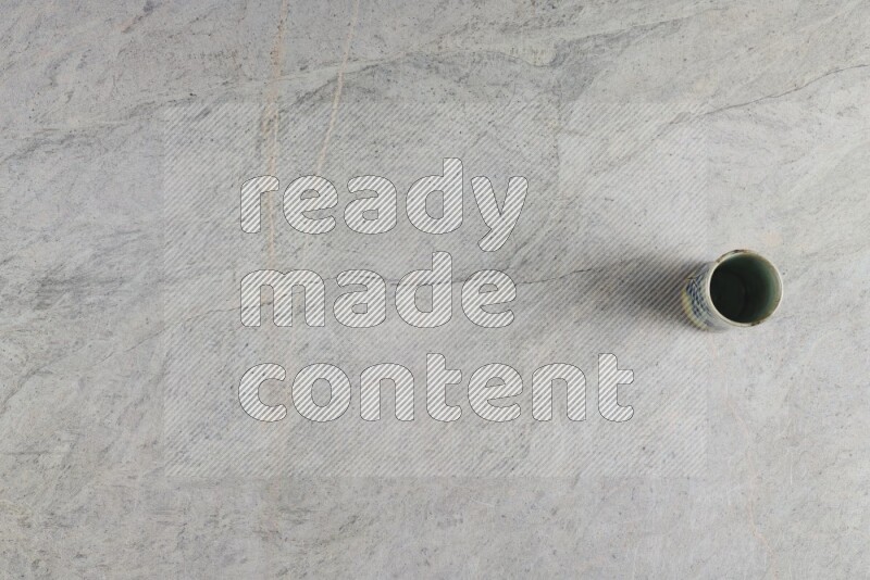 A multicolored pottery Cup on grey marble background