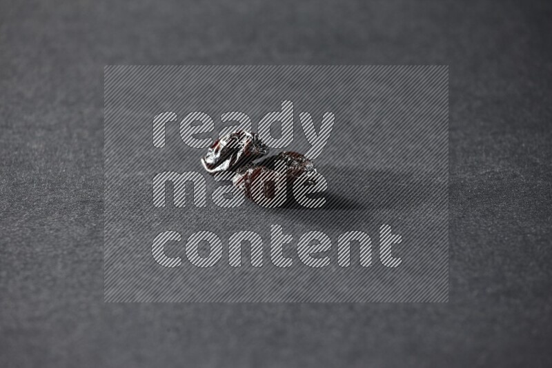 Two dried plums on a black background in different angles