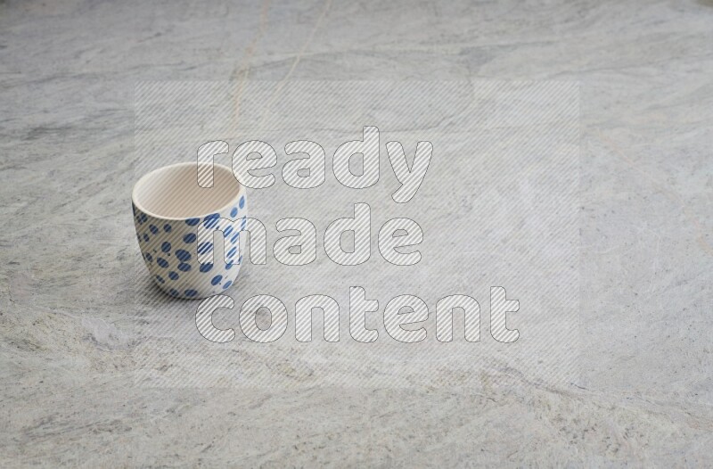 A multicolored pottery Cup on grey marble background