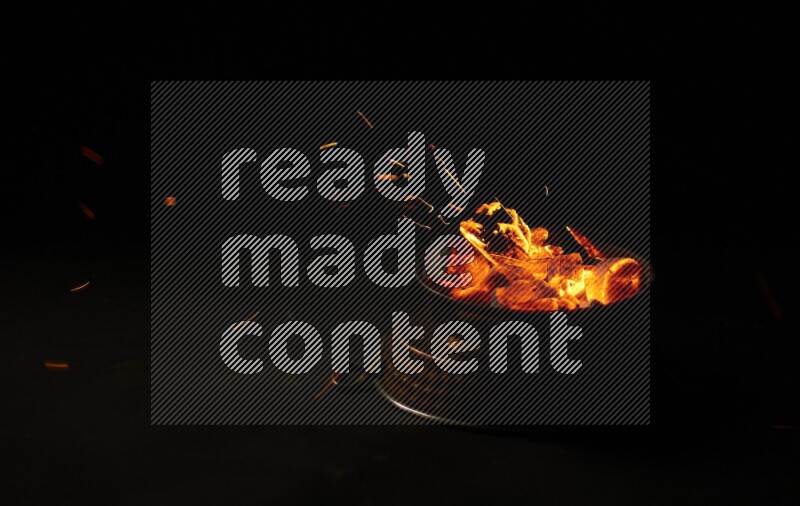 Coal cubes on fire in metal pan