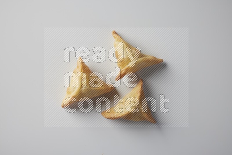 Three fried sambosa from a top angle on a white background
