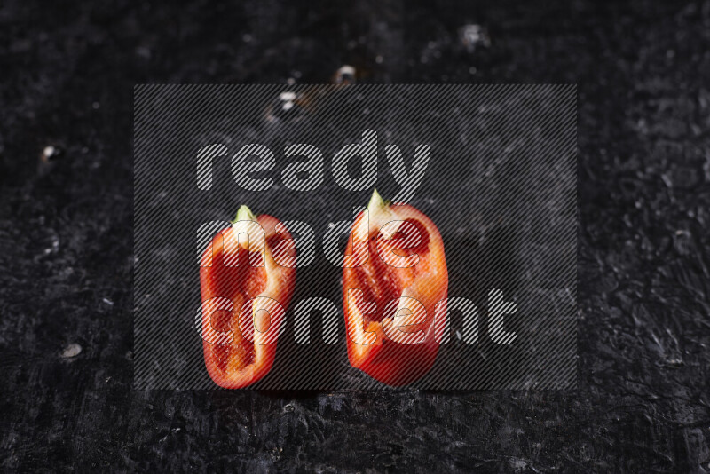 Red bell pepper slices on black background