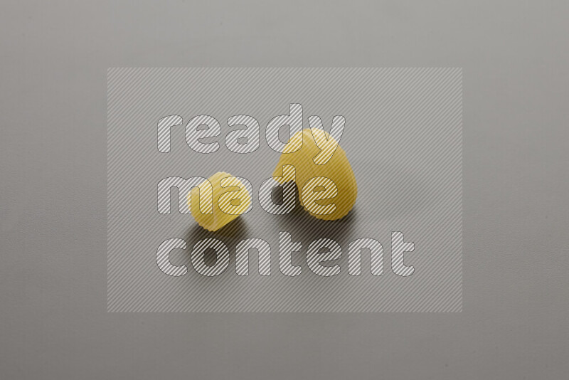 Big rings pasta with other types of pasta on grey background