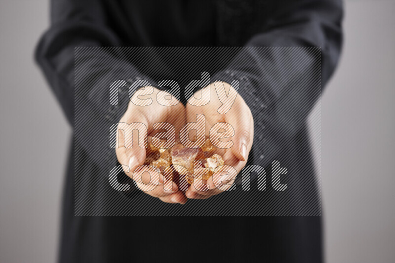 Woman in abaya holding different kinds of spices in different positions