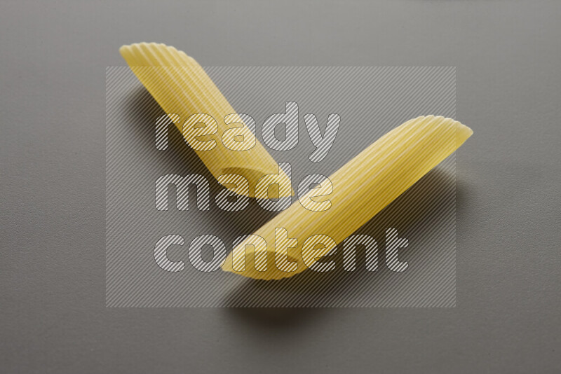 Penne pasta on grey background