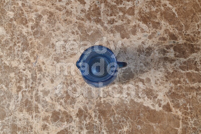 إبريق زجاجي فارغ على خلفية من الرخام البيج