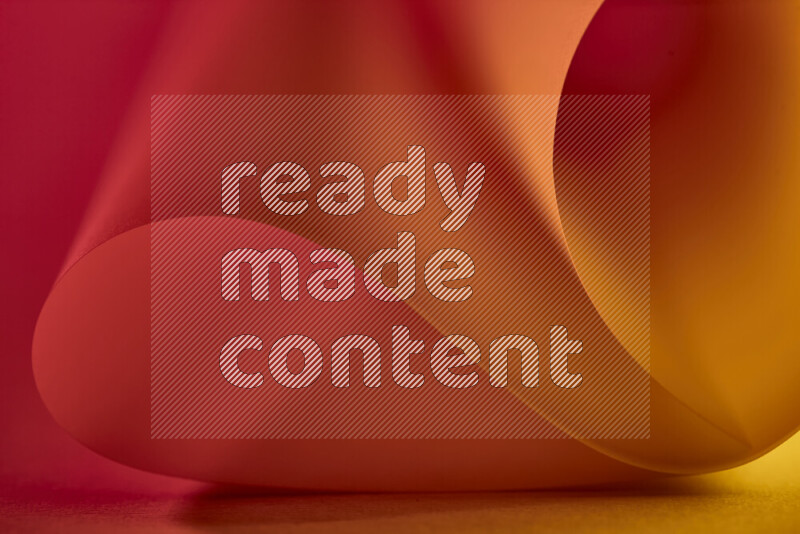 An abstract art piece displaying smooth curves in gold and red gradients created by colored light