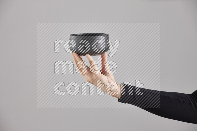 A woman in black abaya holding different pottery essentials in different positions