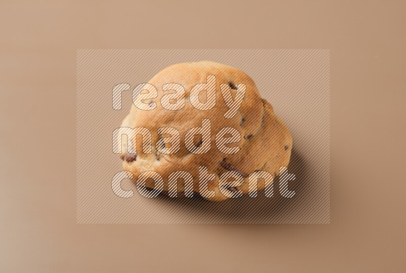 a whole chocolate chip cookie on a brown background