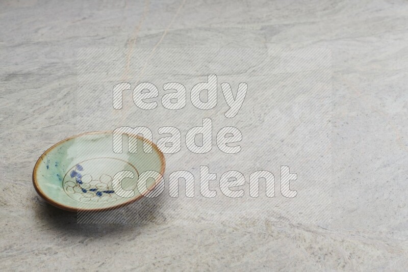 A decorative pottery plate on grey marble background
