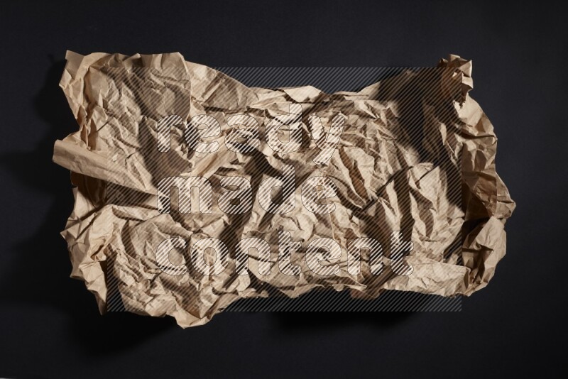 Crumpled craft paper on black background