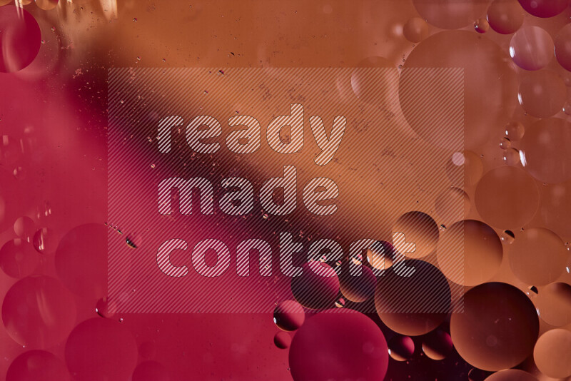 لقطات مقربة لفقاعات من الزيت على سطح الماء باللون الأحمر والبرتقالي