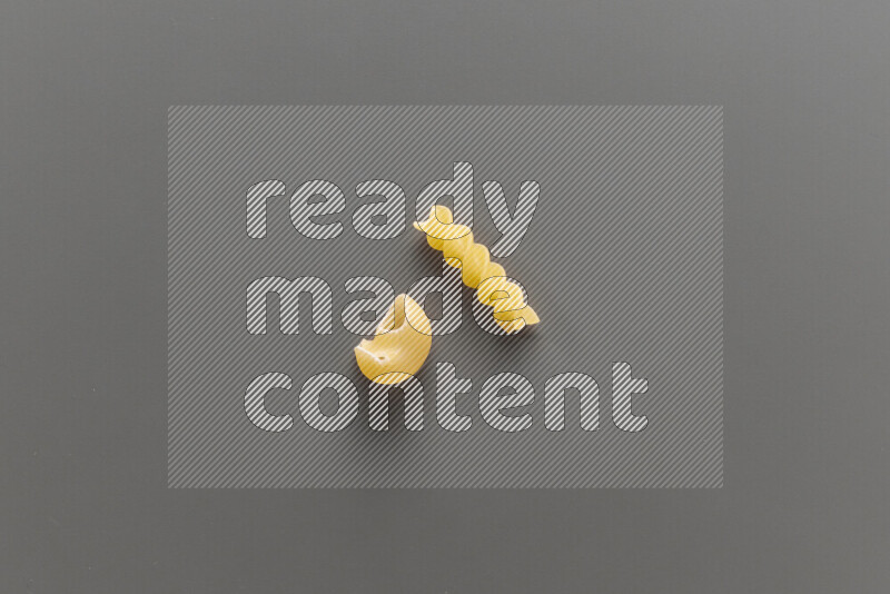 Pipe pasta with other types of pasta on grey background