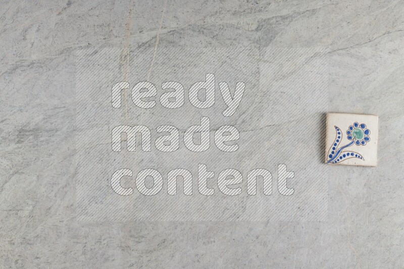 A decorative pottery coaster on grey marble background