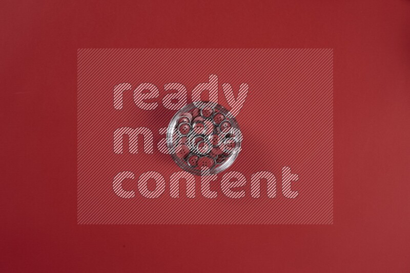 A red collection of sewing and tailoring tools arranged on a red background