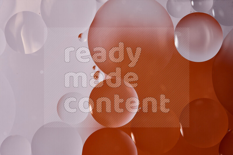 Close-ups of abstract oil bubbles on water surface in shades of white and orange