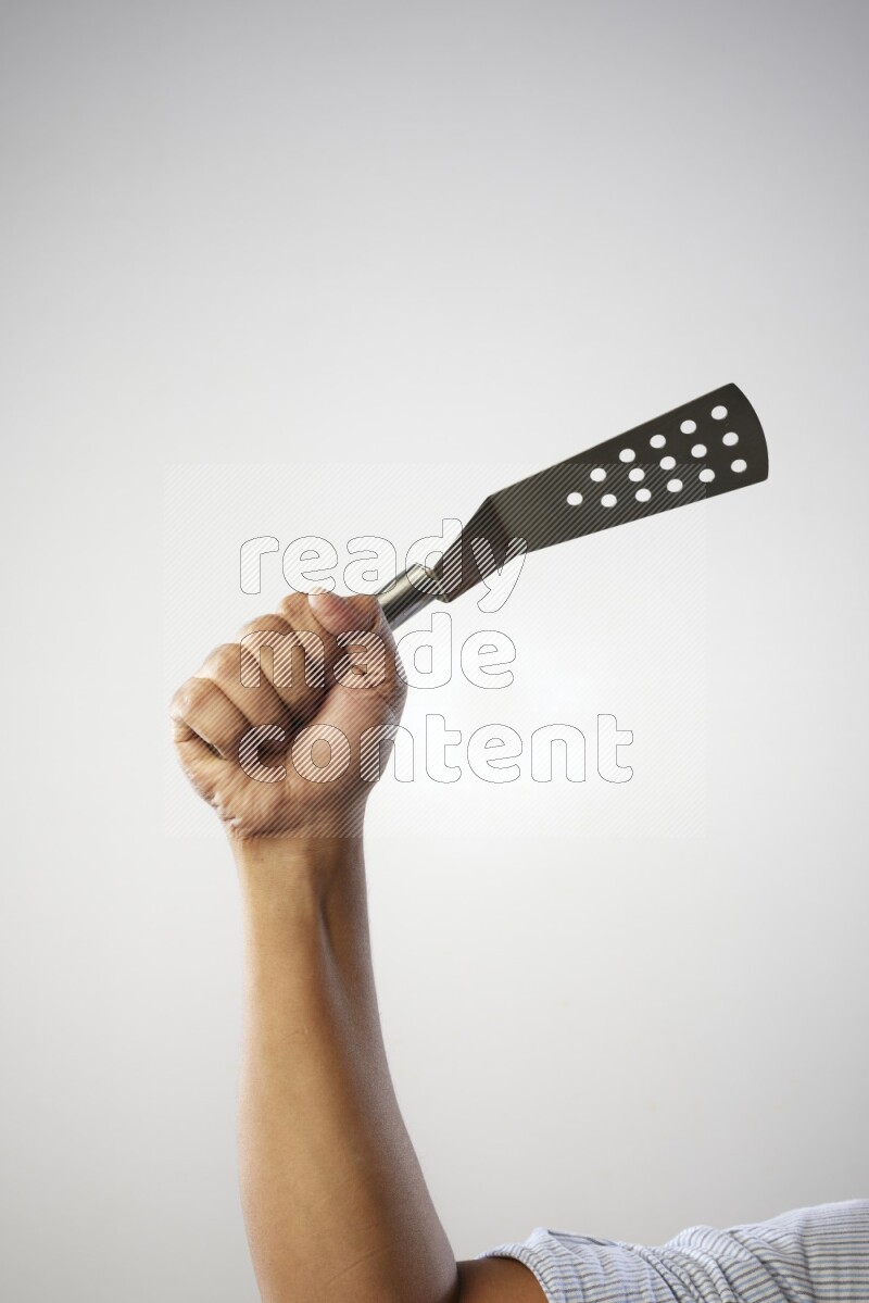 Male Hand Holding Burger Flipper on white background