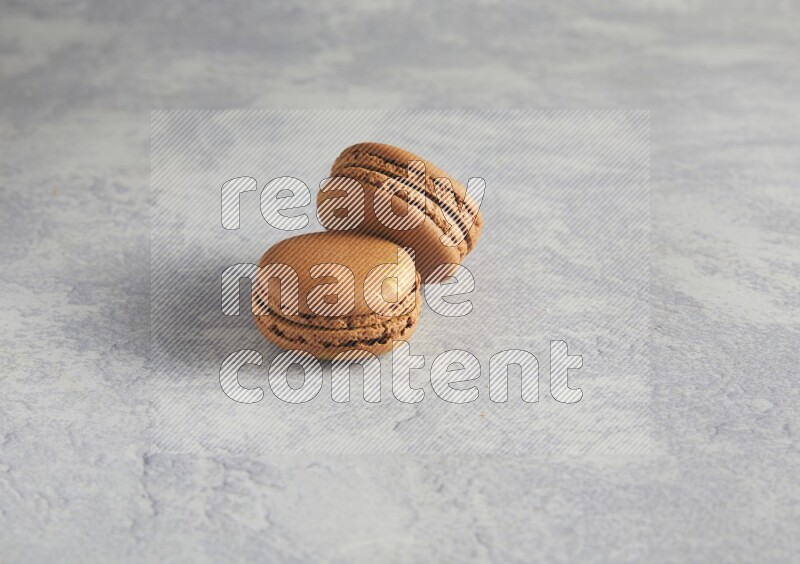 45º Shot of two Brown Coffee macarons  on white  marble background