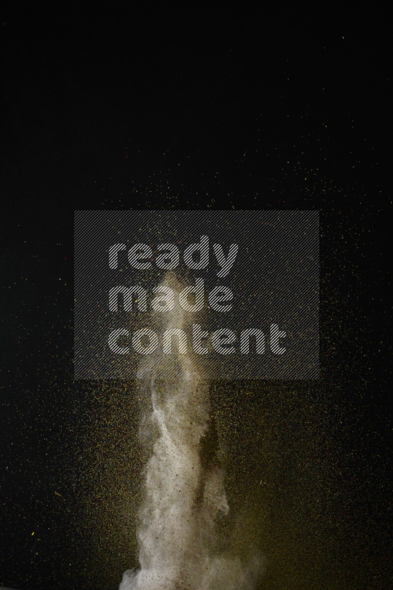 A side view of brown powder explosion on black background