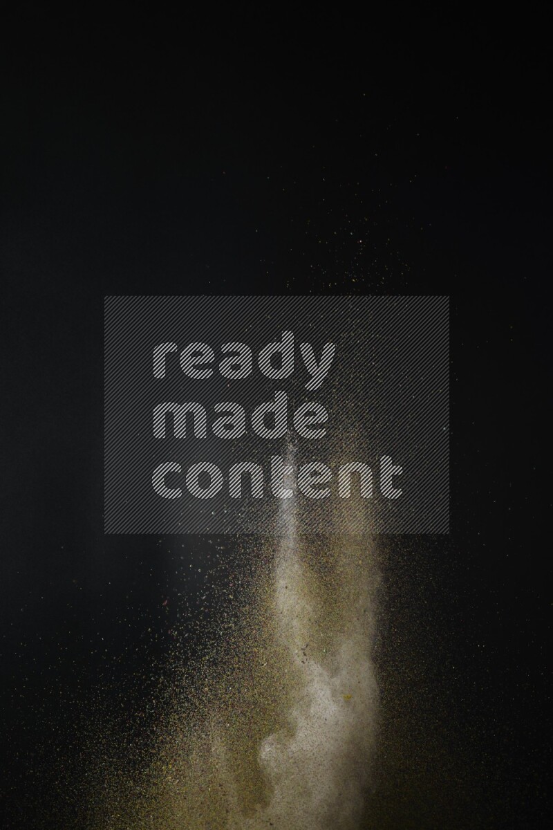 A side view of brown powder explosion on black background