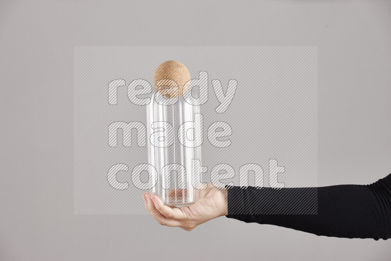 A woman in black abaya holding different glassware in different positions