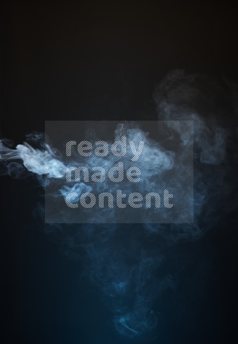 Heavy smoke in blue and yellow isolated on black background