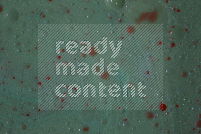 The image captures a dramatic splatter of red paint over a green backdrop