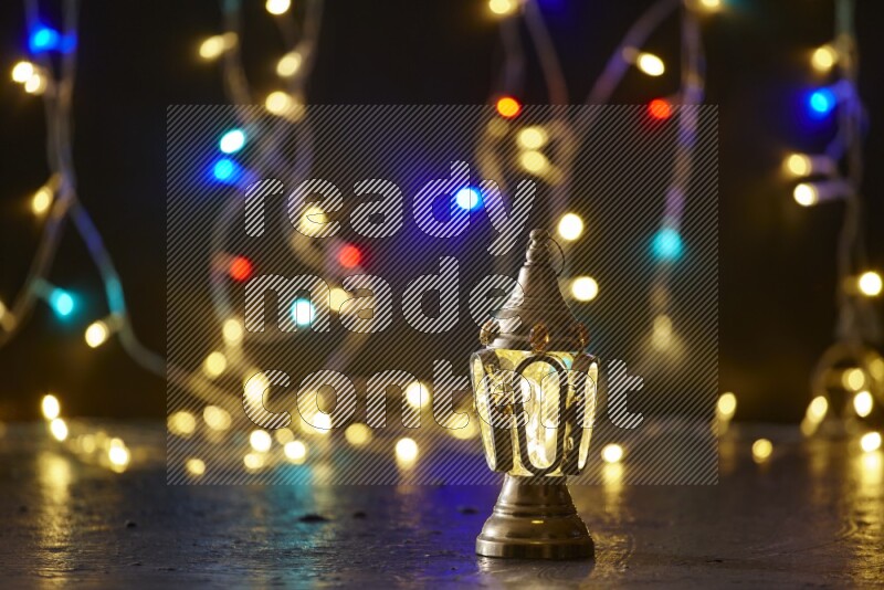 A traditional ramadan lantern surrounded by glowing fairy lights in a dark setup