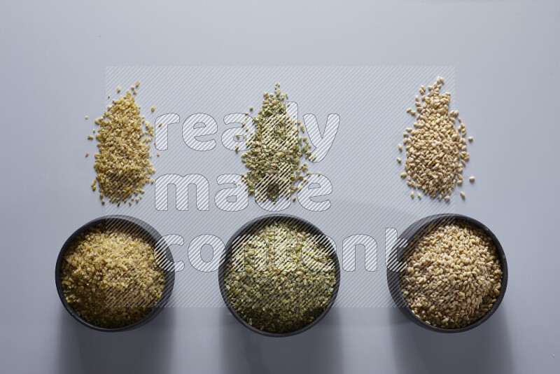 Legumes in pottery bowls on light grey background