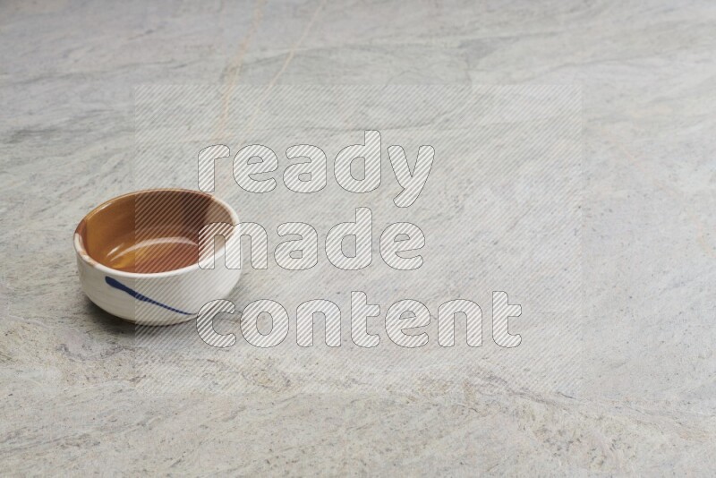 A multicolored pottery bowl on grey marble background