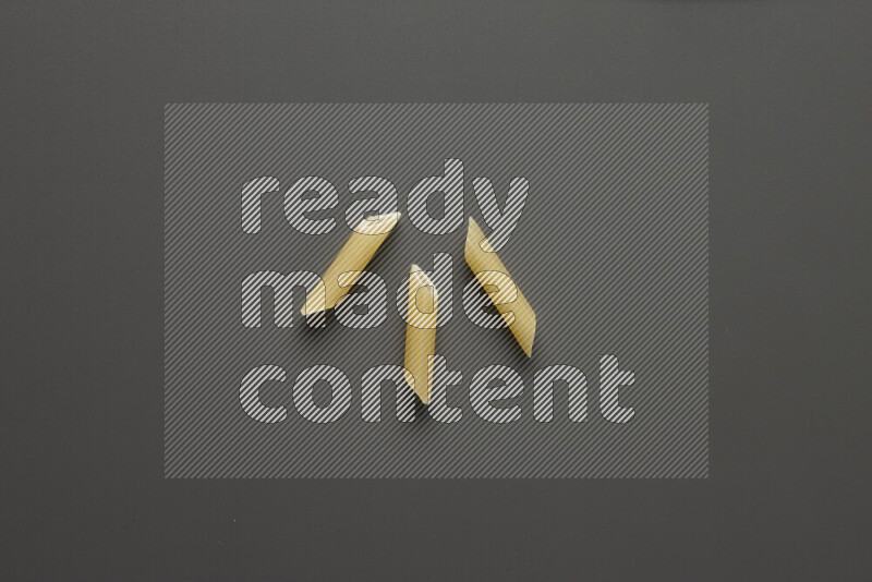Mini penne pasta on grey background