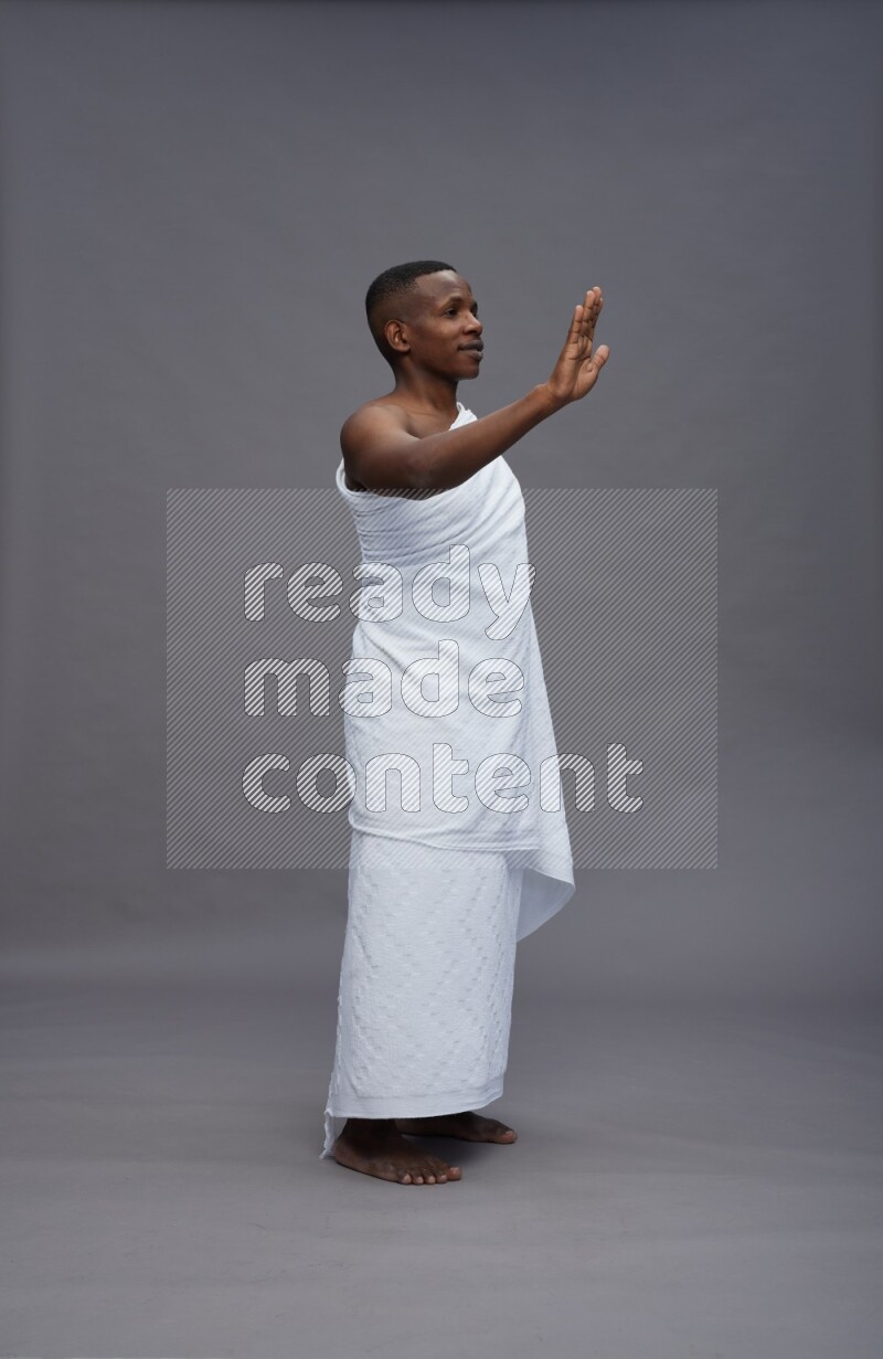 A man wearing Ehram Standing Interacting with the camera on gray background
