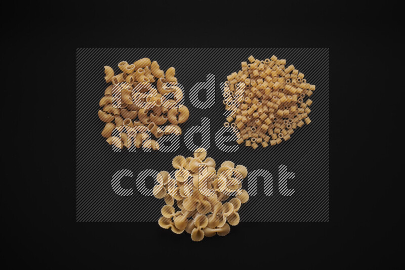 Different pasta types in bunches on black background