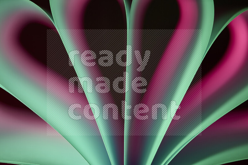 فن تجريدي يعرض منحنيات وتدرجات اللون الوردي والأخضر مكونه بضوء ملون