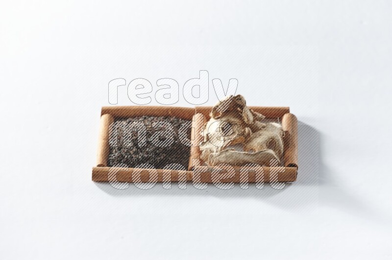 2 squares of cinnamon sticks full of black tea and dried ginger on white flooring